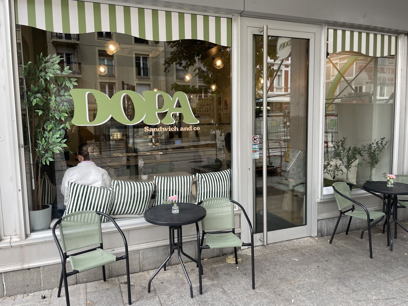 Devanture verte et blanche de DOPA avenue Kennedy, avec sa terrasse